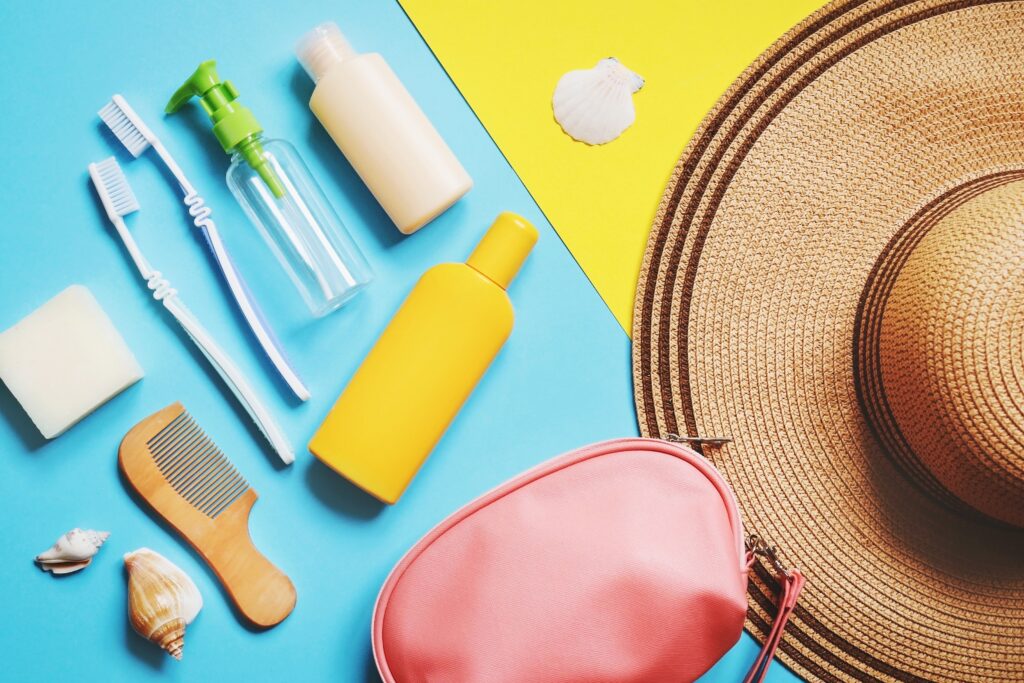 Photo of travel sized skincare products with beach hat