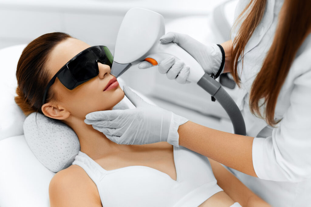 Woman receiving laser hair removal treatment on face